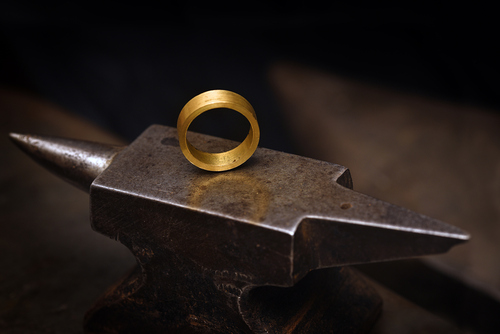 Ein geschmiedeter goldener Ring am Ambos.